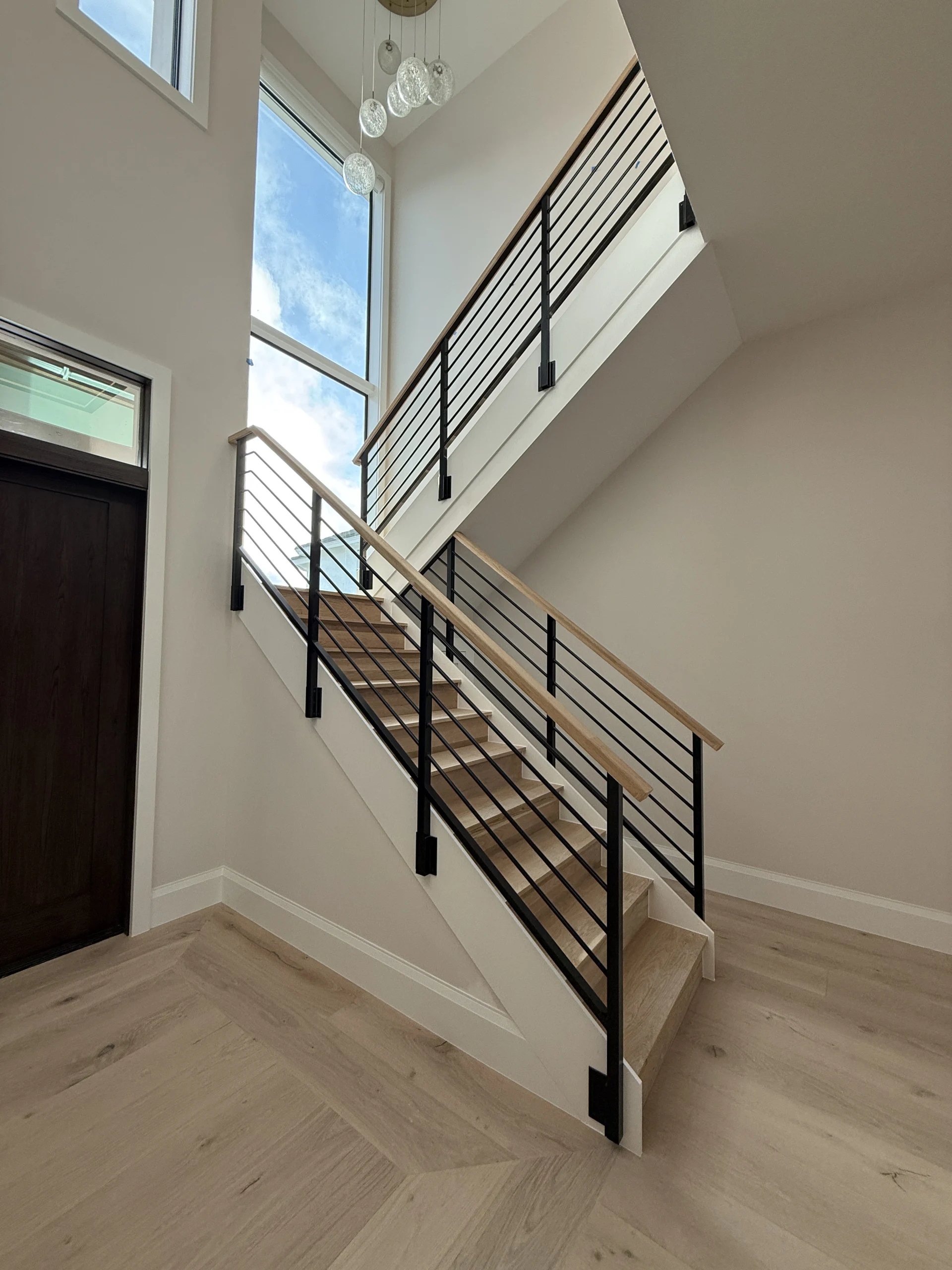 Headwaters – Horizontal Rod Rail – Wood Top Cap (1) – Interior Rod Rail Horizontal aluminum rod railing with a continuous top cap at Headwaters