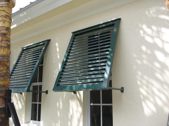 Aluminum bahama shutters mounted above exterior windows